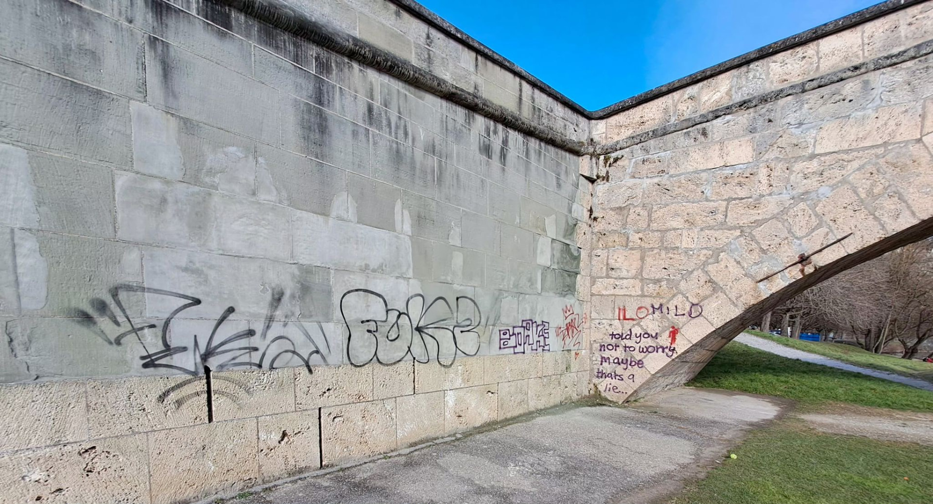 Graffiti-Entfernung an einer Natursteinmauer