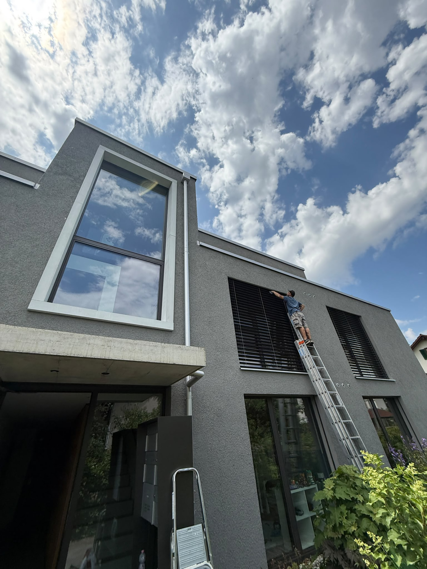 Fensterreinigung an einem modernen Wohnhaus